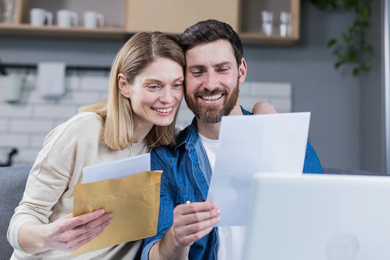 Happy homeowners reviewing property tax documents together at home, representing Texas property tax protest and savings services by Tax Cutter.