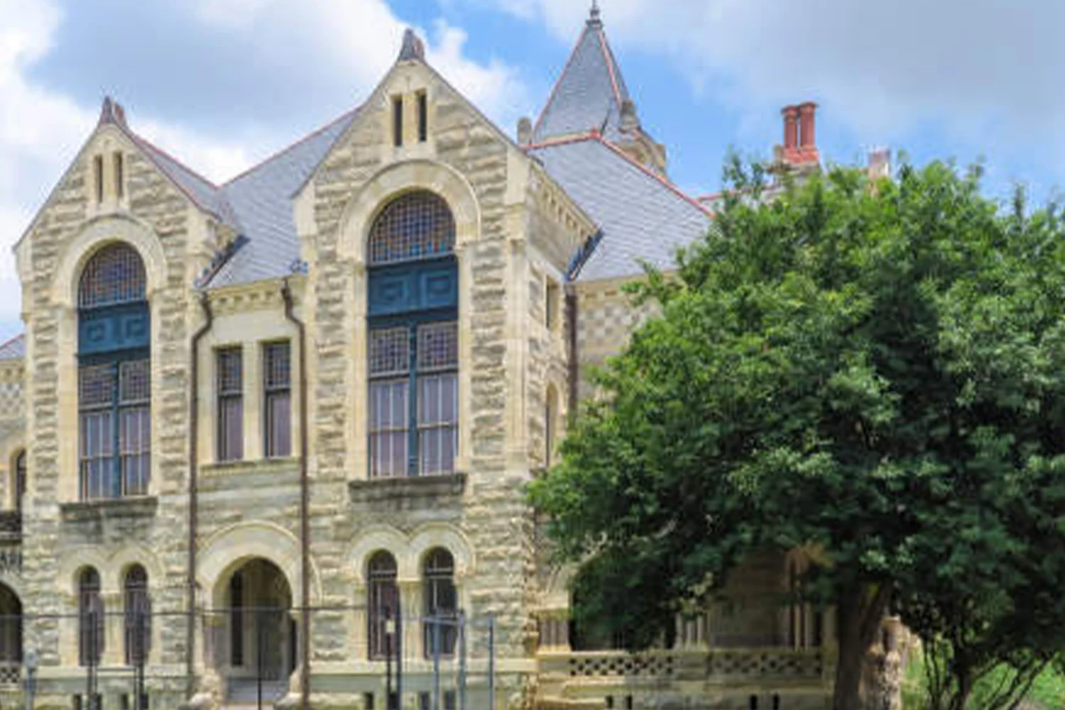 Victoria County Courthouse in Texas with historic stone facade and arched windows, supporting property tax protest services by Tax Cutter.