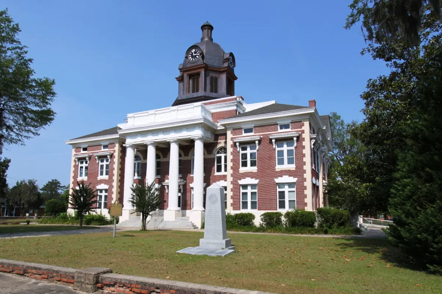 Historic Montgomery County Courthouse in Texas with clock tower and columns, representing Houston property tax protest services by Tax Cutter. 