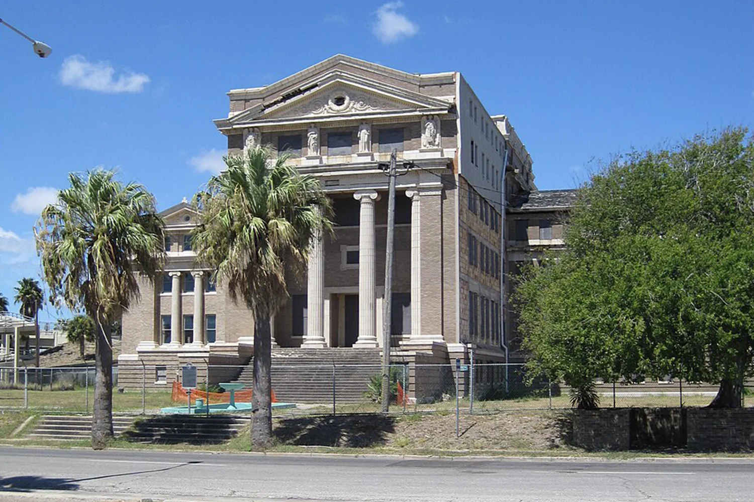 Historic Texas courthouse with columns and palm trees, representing professional property tax protest and appeal services by Tax Cutter.