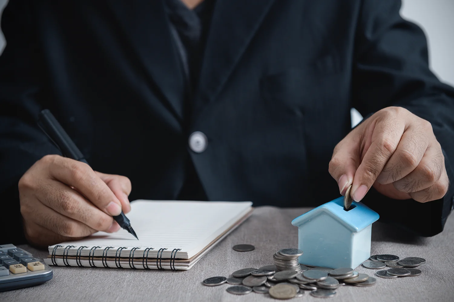 Property owner depositing coins into house model, symbolizing Houston property tax savings through Tax Cutter property tax protest services.