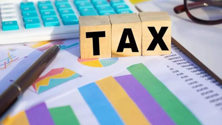 Wooden blocks spelling tax with calculator and charts, representing Houston property tax protest and reduction services by Tax Cutter