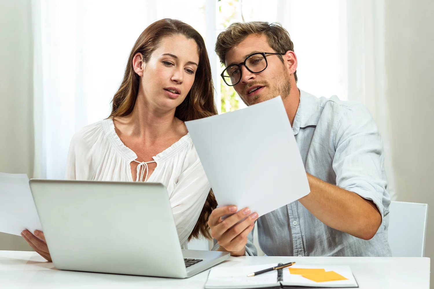 Couple reviewing property tax documents and discussing their options, representing how Tax Cutter helps homeowners navigate property tax protests in Houston.