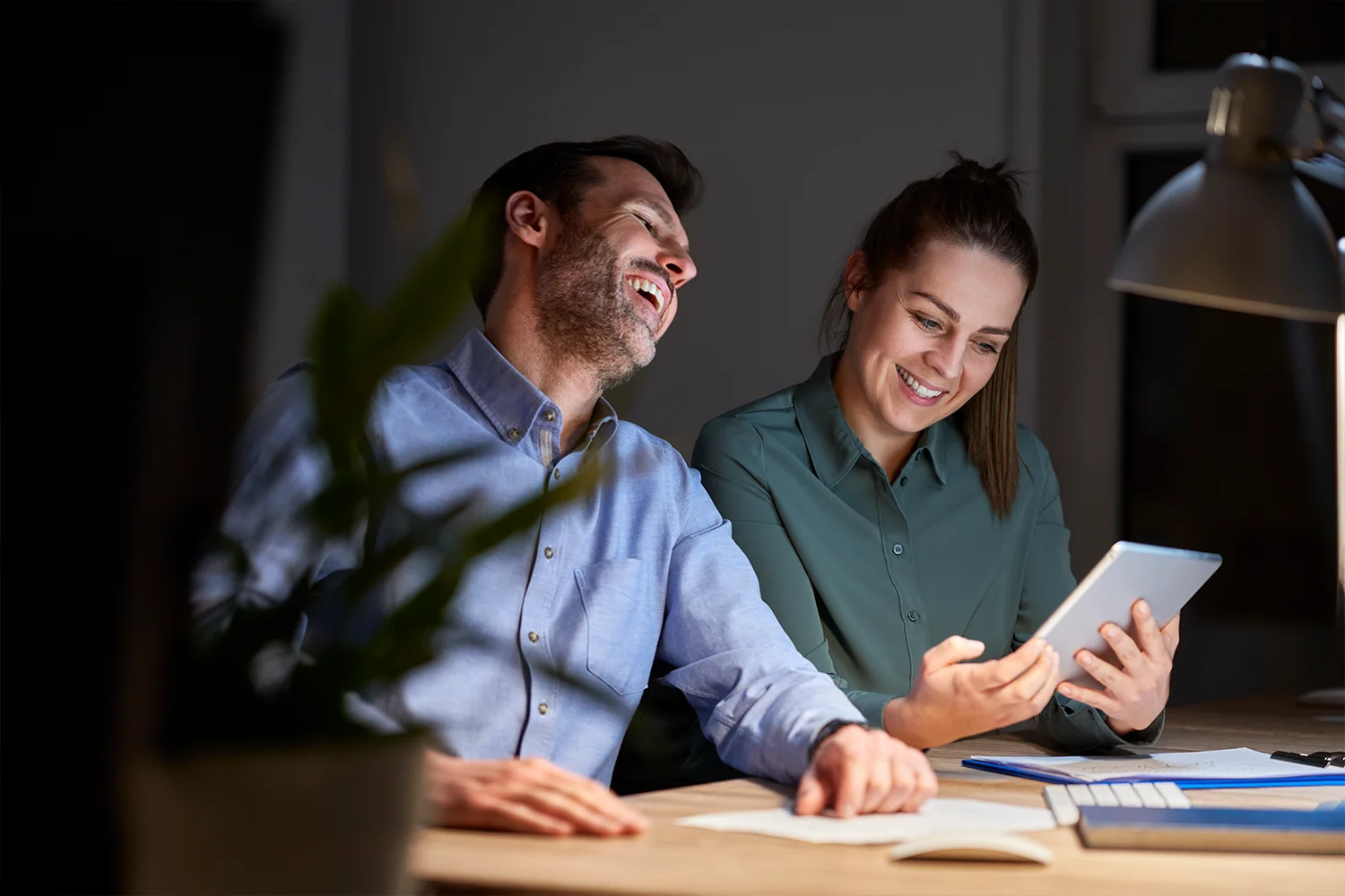 Happy Houston couple reviewing property tax savings on tablet after successful property tax protest by Tax Cutter. 