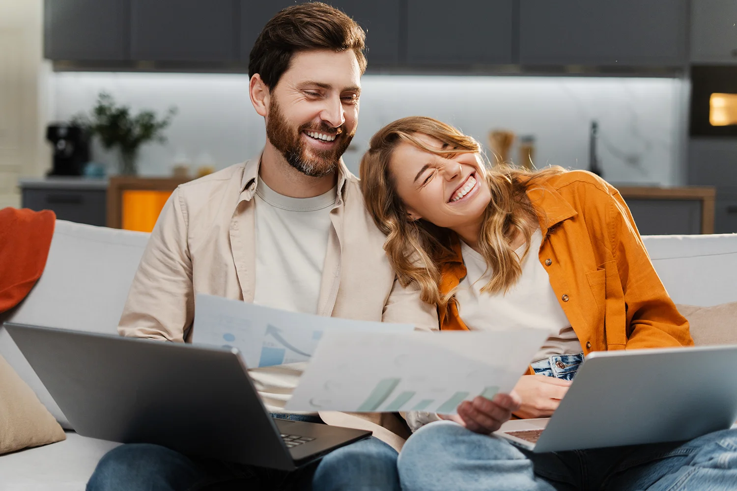 Happy Houston homeowners reviewing property tax savings documents with laptops, representing successful property tax protest by Tax Cutter.