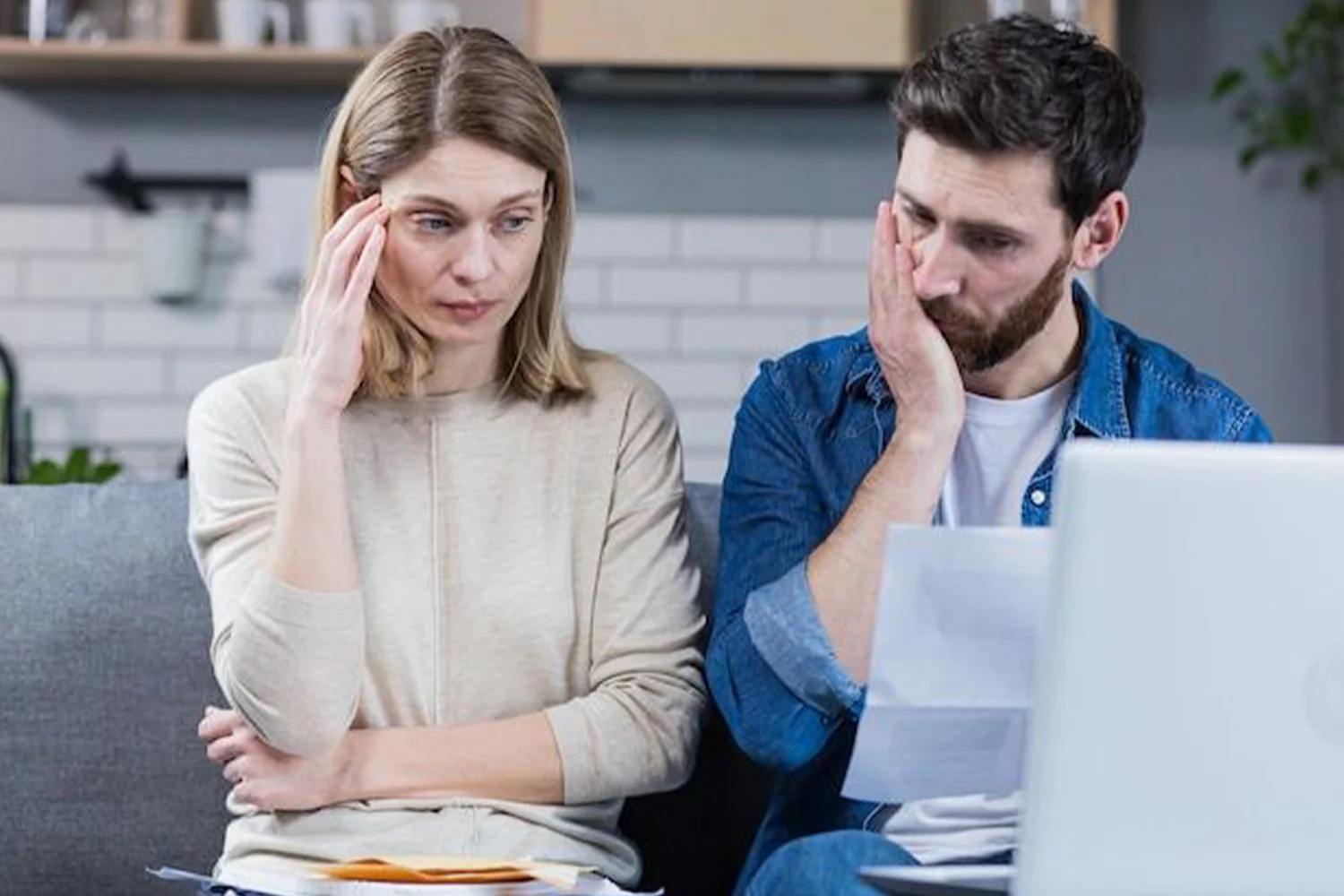 Couple stressed and frustrated while reviewing property tax documents, symbolizing the need for property tax protest services from Tax Cutter in Houston.