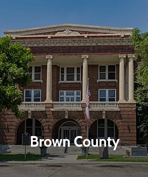 Brown County Courthouse in Texas with classic columns and brick exterior, representing property tax protest services by Tax Cutter in Houston.