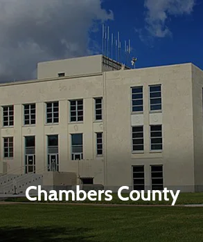Chambers County Courthouse in Texas with modern stone exterior and large windows under a bright blue sky.