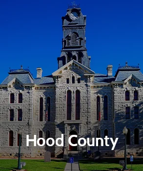 Hood County Courthouse in Texas with historic stone architecture and clock tower, representing Houston property tax protest services by Tax Cutter.