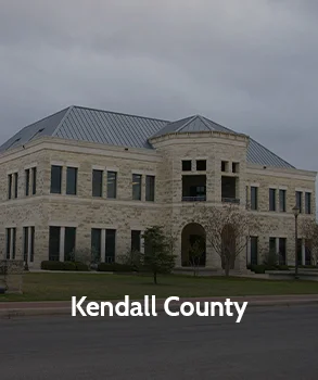 Kendall County Courthouse in Texas with limestone exterior, arched entryway, and modern design under an overcast sky
